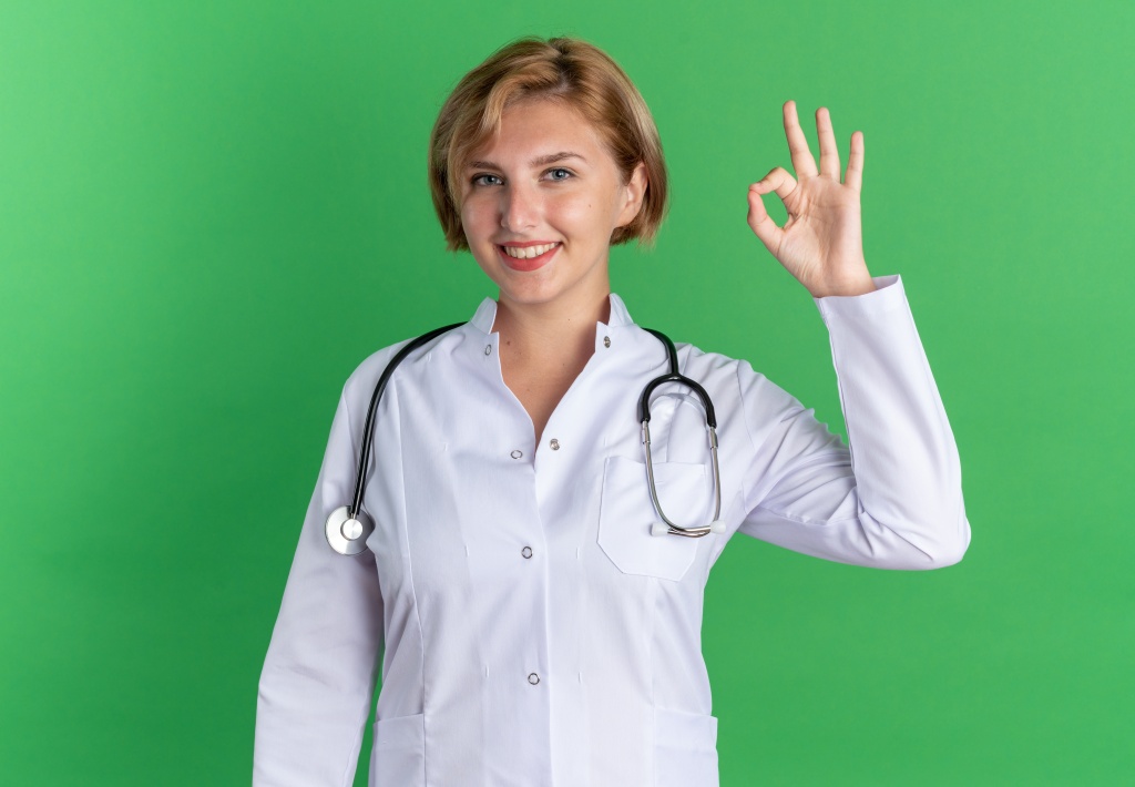 smiling-young-female-doctor-wearing-medical-robe-with-stethoscope-showing-okay-gesture-isolated-on-green-background.jpg